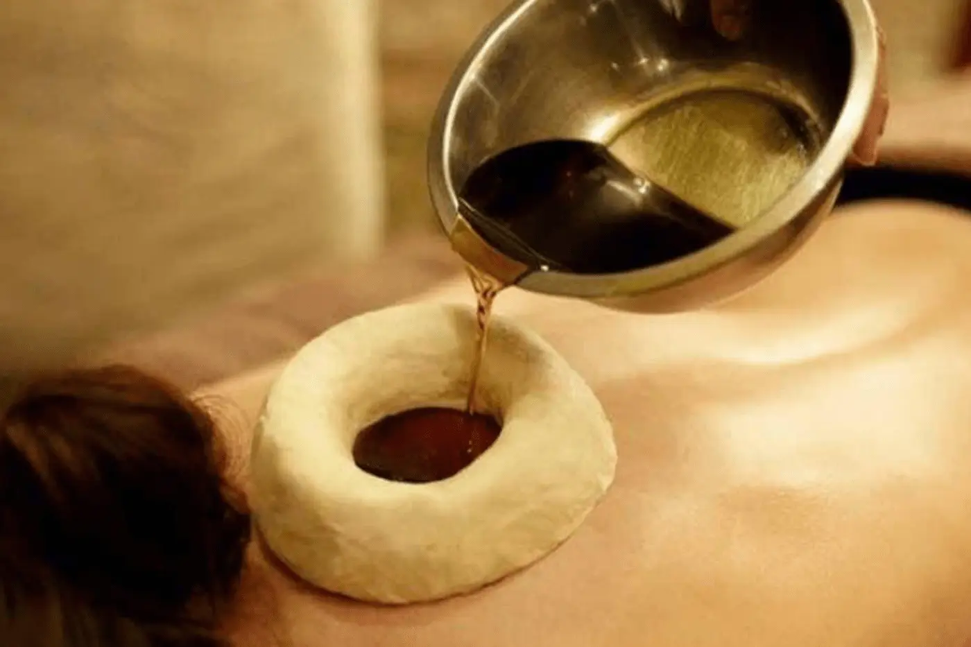 Warm medicated oil held over the neck to ease cervical pain